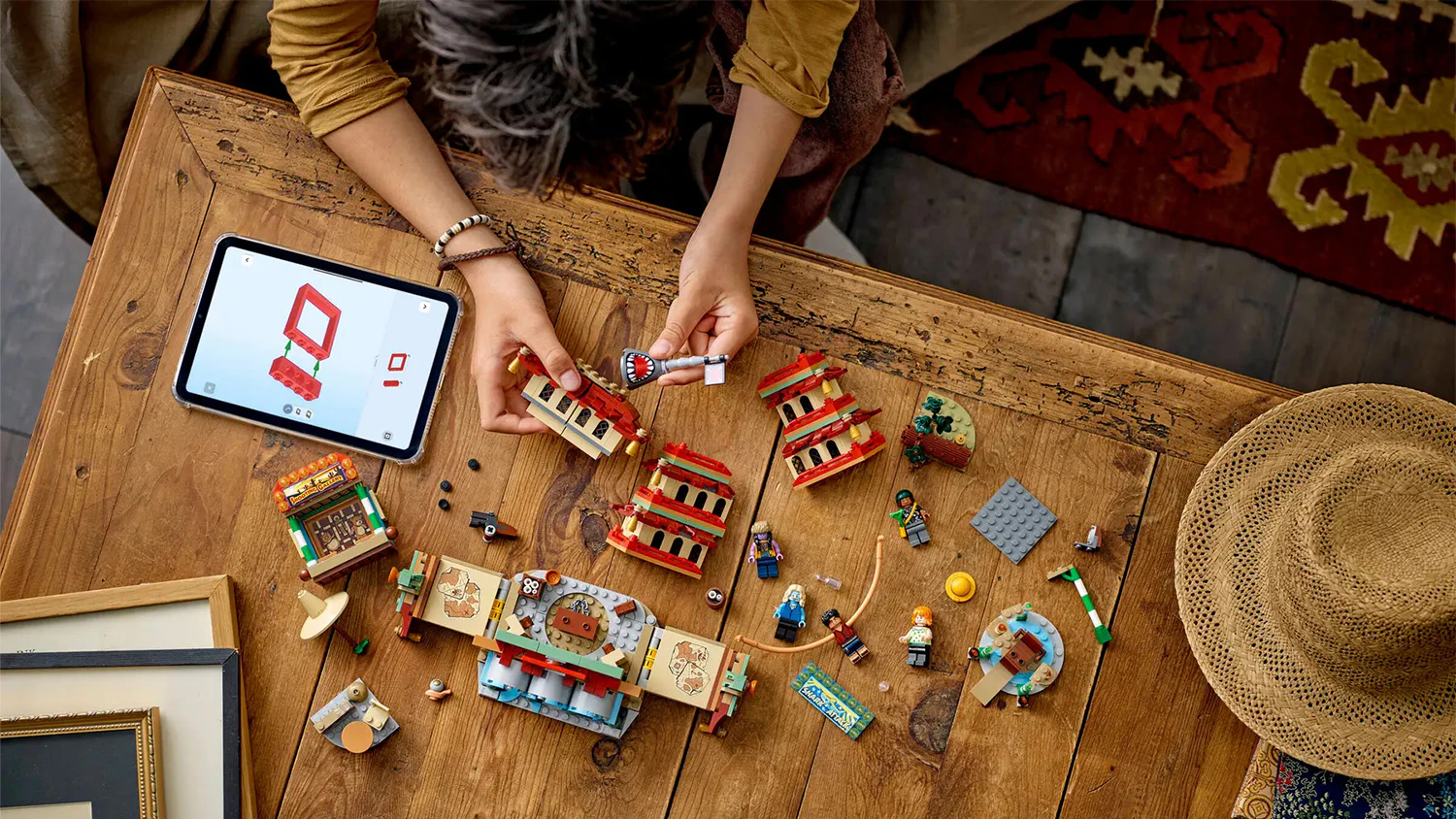 Chlapec stavia stavebnicu LEGO&reg; One Piece 75638 Bitka o Arlong Park s n&aacute;vodom otvoren&yacute;m na tablete v aplik&aacute;cii LEGO&reg;