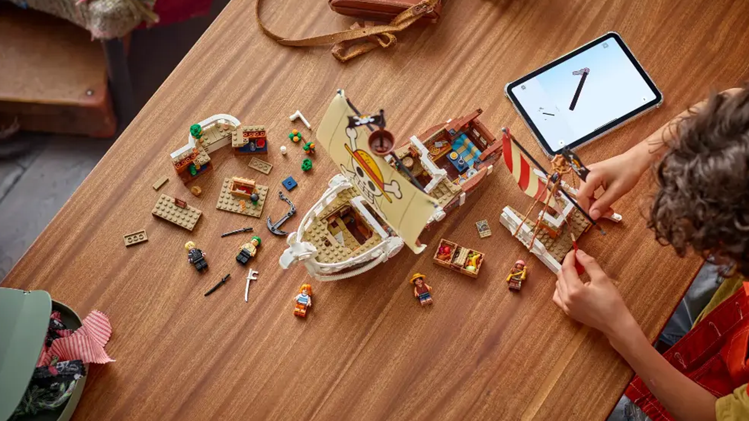 Dítě sestavuje stavebnici LEGO® ONE PIECE 75639 Pirátská loď Plovoucí Merry s pomocí aplikace LEGO® Builder v tabletu_04