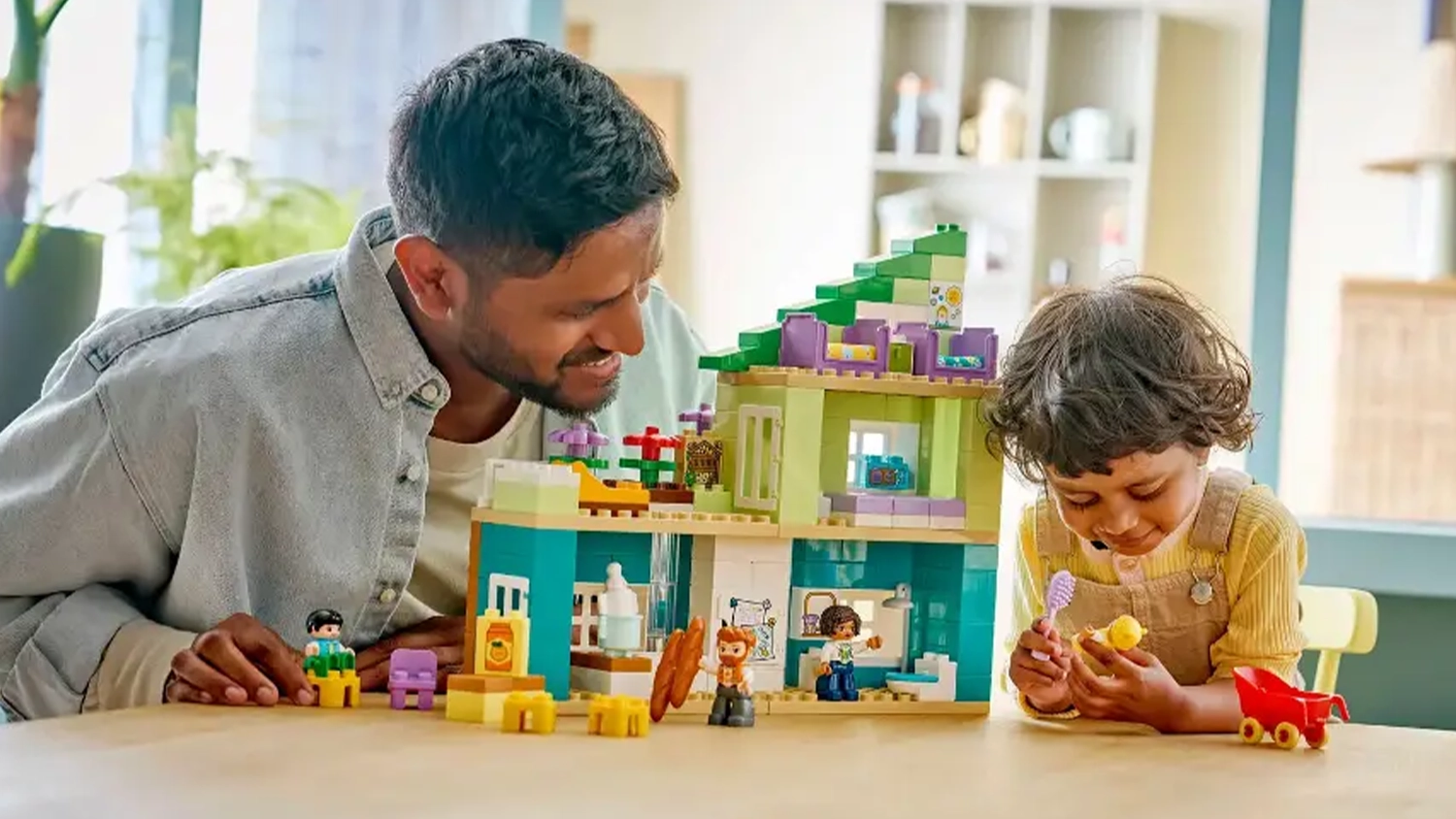 Usm&iacute;vaj&iacute;c&iacute; se muž s holčičkou si hraj&iacute; se stavebnic&iacute; LEGO&reg; DUPLO&reg; 10470 Modern&iacute; rodinn&yacute; dům 3v1 s figurkami.