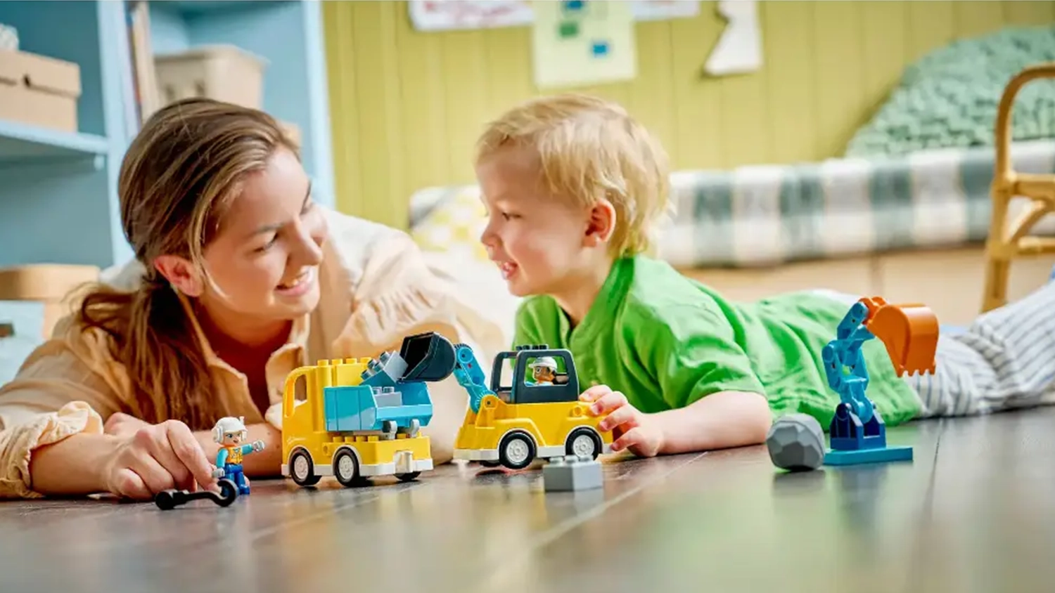 Usm&iacute;vaj&iacute;c&iacute; se žena s mal&yacute;m chlapcem si hraj&iacute; se stavebnic&iacute; LEGO&reg; DUPLO&reg; Město 10475 Vozidla na stavbě 3v1.