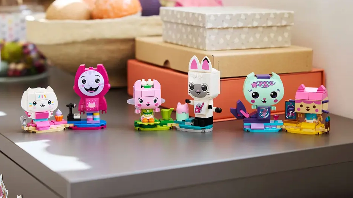 Figúrky zo stavebnice LEGO® Gabby’s Dollhouse 11215 Gabby a mačací kamaráti z kociek vystavené na skrinke.