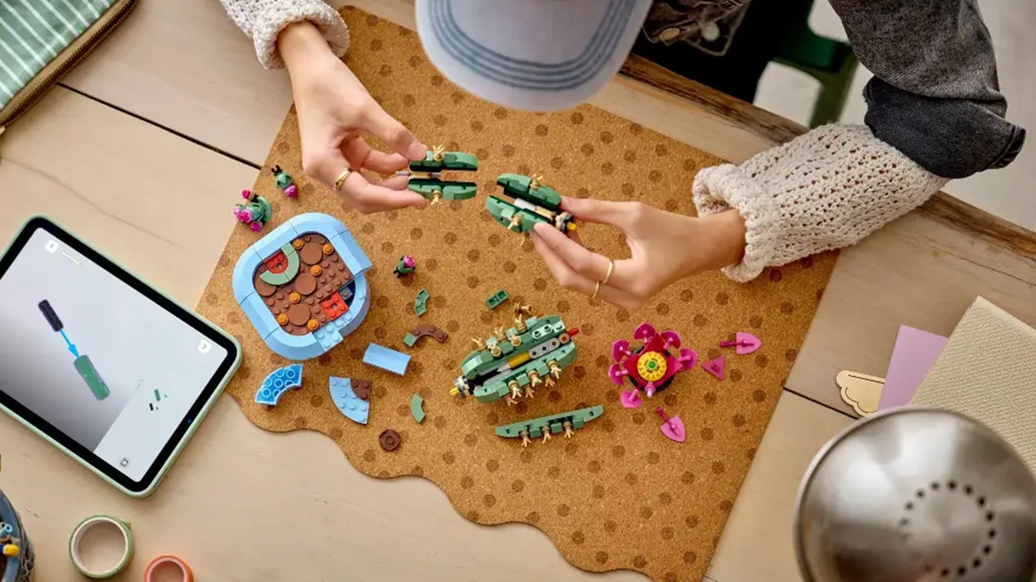D&iacute;vka skl&aacute;d&aacute; stavebnici LEGO&reg; Botanicals 11509 Kvetouc&iacute; kaktus s pomoc&iacute; n&aacute;vodu v aplikaci LEGO&reg; Builder na tabletu.