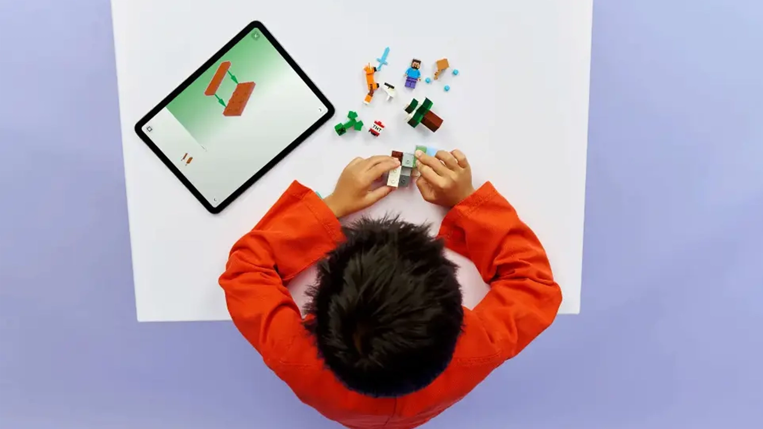 Chlapec skl&aacute;d&aacute; stavebnici LEGO&reg; Minecraft&reg; 21583 Steve a dobrodružstv&iacute; v tajze s pomoc&iacute; aplikace LEGO Builder na tabletu.