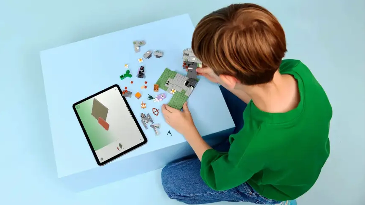 Chlapec skladá stavebnicu LEGO® Minecraft® 21586 Bledá záhrada s pomocou návodu v aplikácii LEGO® Builder na tablete.
