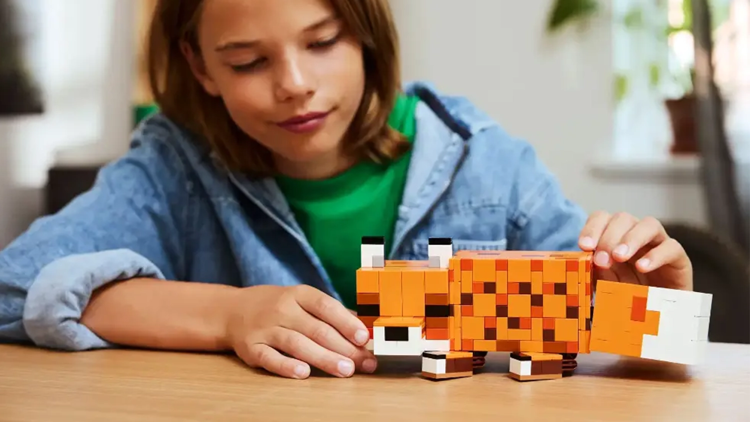Dievča sa hr&aacute; s l&iacute;&scaron;kou zo stavebnice LEGO&reg; Minecraft&reg; (21588) a men&iacute; jej polohu.