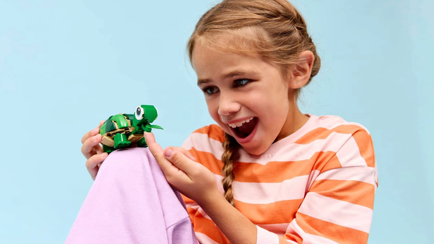 Vesel&eacute; dievčatko sa hr&aacute; s fig&uacute;rkou zo stavebnice LEGO&reg; Creator 3v1 31377 korytnačka s leknom.