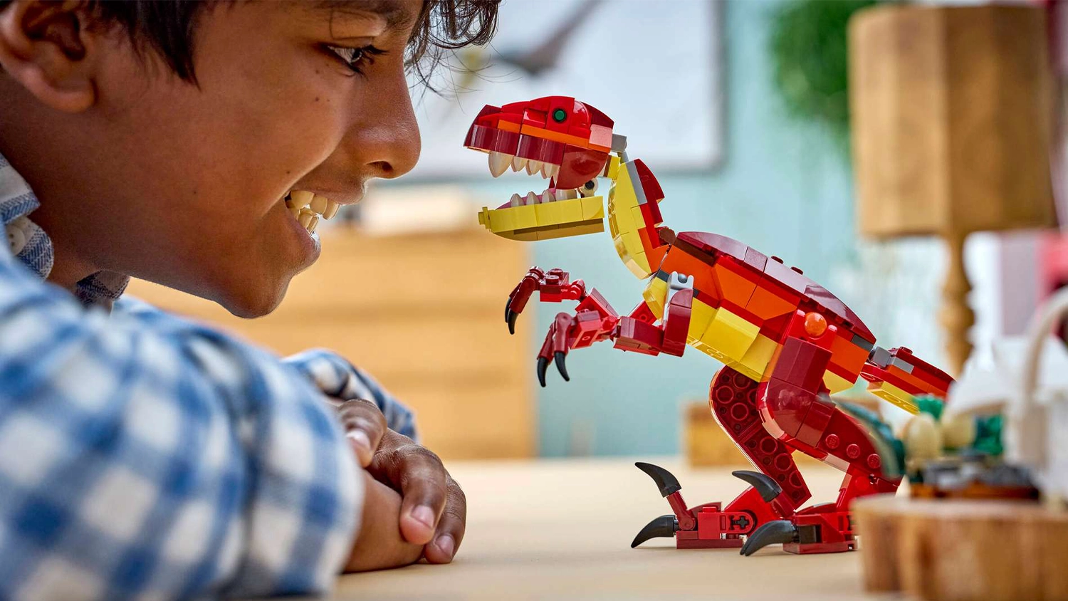 Chlapec sa usmieva na velociraptora zo stavebnice LEGO&reg; Creator 3 v 1 31379 Divok&yacute; dinosaurus.