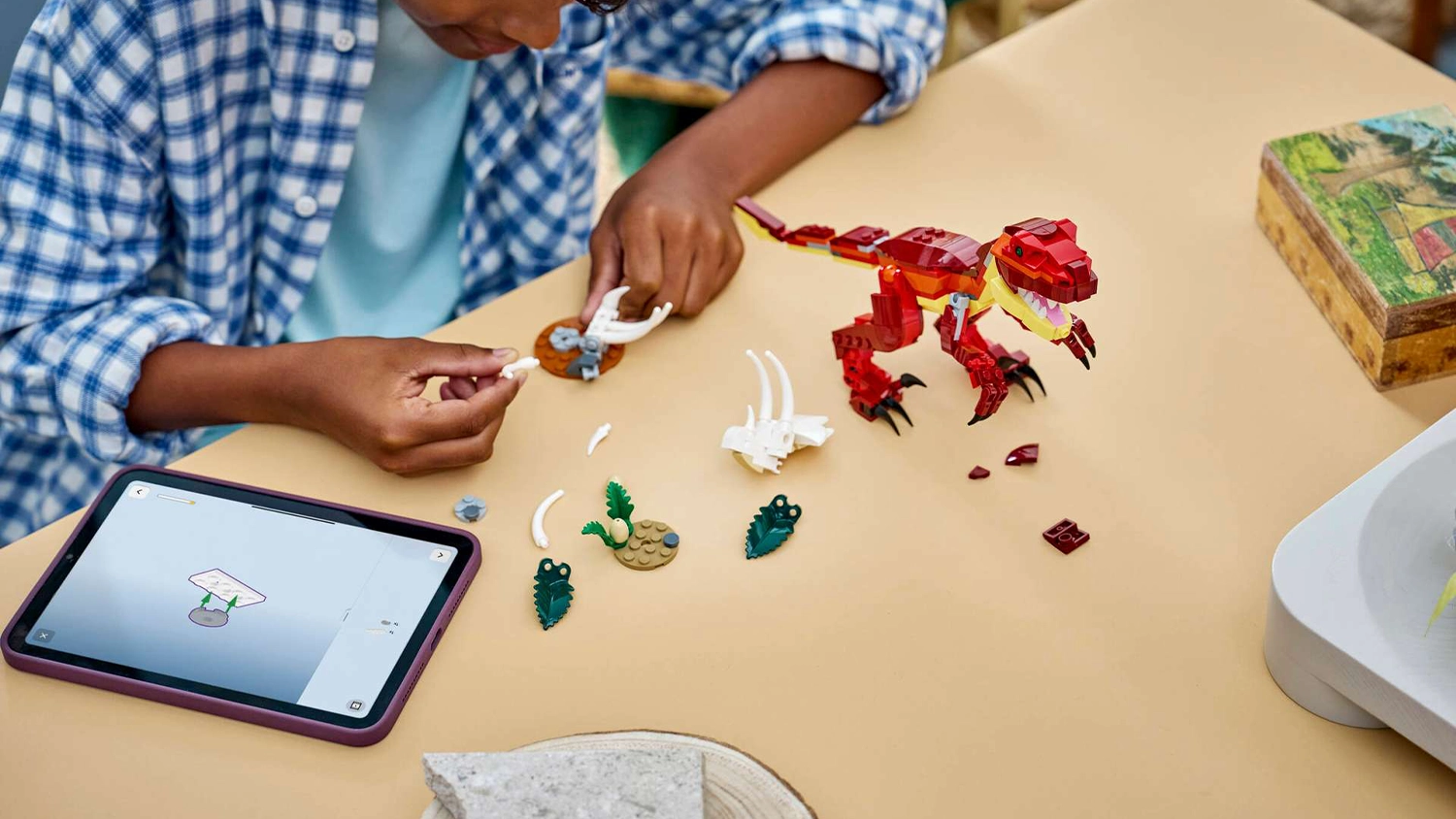 Chlapec sklad&aacute; stavebnicu LEGO&reg; Creator 3 v 1 31379 Divok&yacute; dinosaurus s pomocou aplik&aacute;cie LEGO&reg; Builder na tablete.