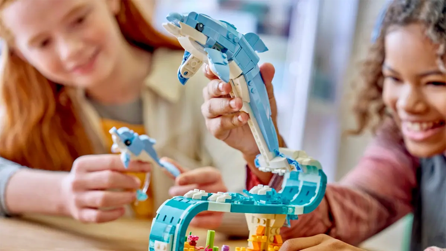 Dvě dívky drží v ruce model ze stavebnice LEGO® Creator 3 v 1 31385 Mořští živočichové: Krásní delfíni