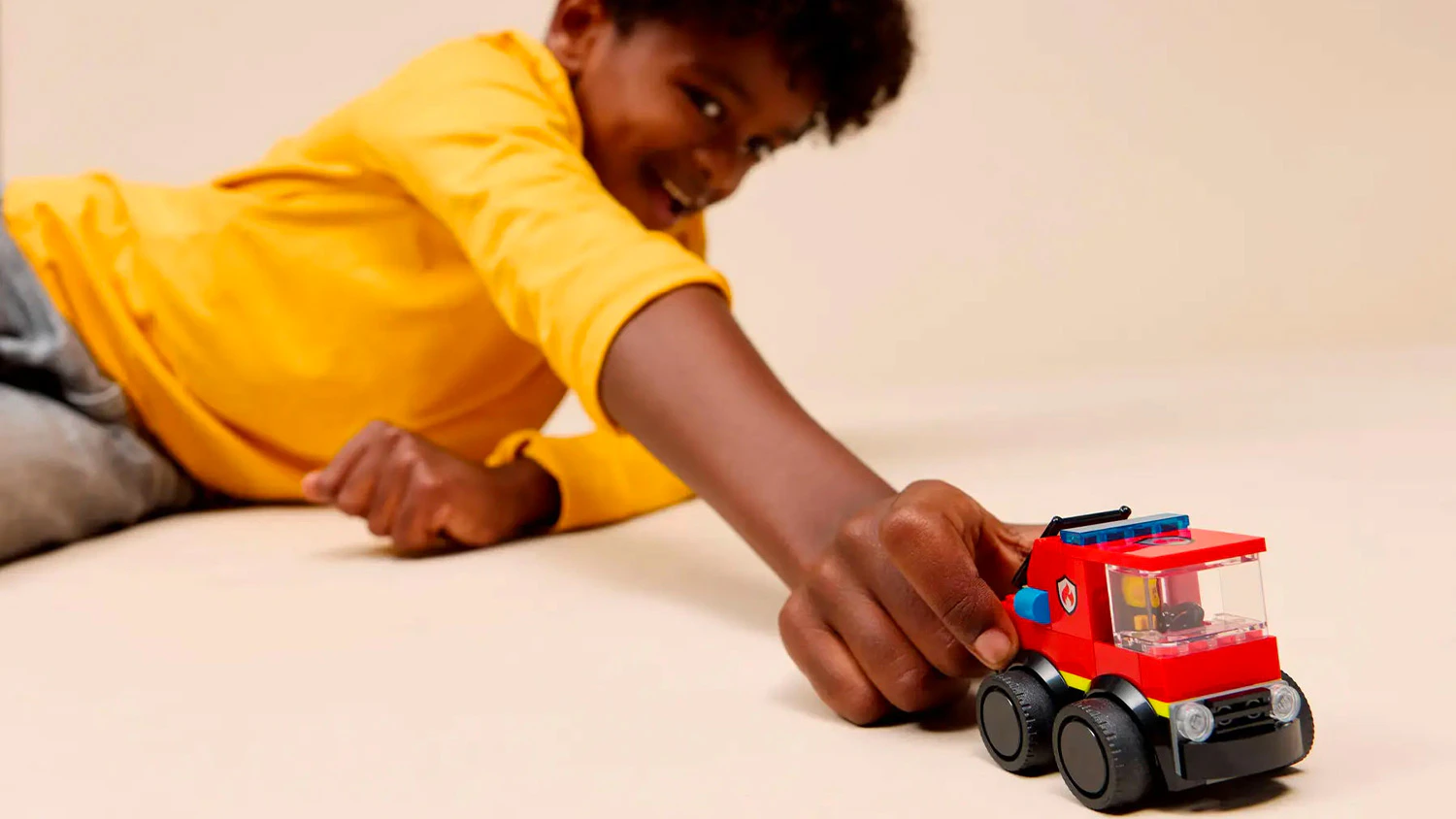 Chlapec sa hr&aacute; s modelom hasičsk&eacute;ho aut&iacute;čka LEGO&reg; City 60482
