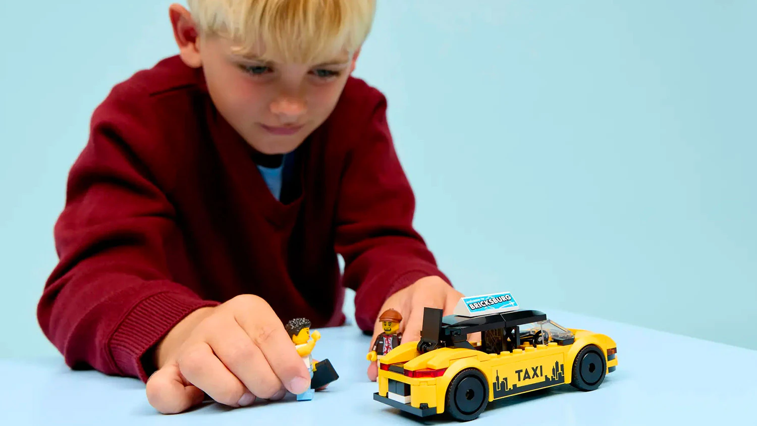 Chlapec hrající si s modelem Žlutý taxík LEGO® City 60487
