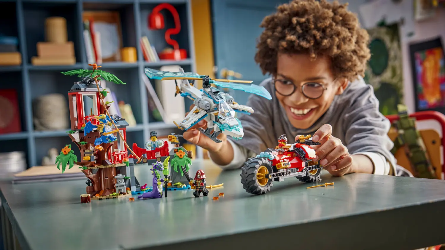 Dieťa sa hr&aacute; so stavebnicou LEGO&reg; NINJAGO&reg; 71857 S&uacute;boj nindža vozidiel a domček na strome