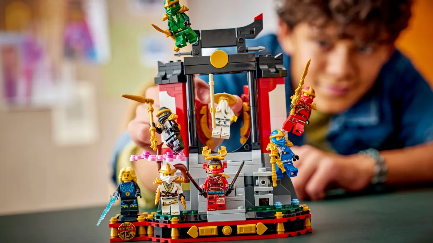 Kluk hraj&iacute;c&iacute; si se stavebnic&iacute; LEGO&reg; NINJAGO&reg; 71866 V&yacute;stavka nindžů: 15 let NINJAGO