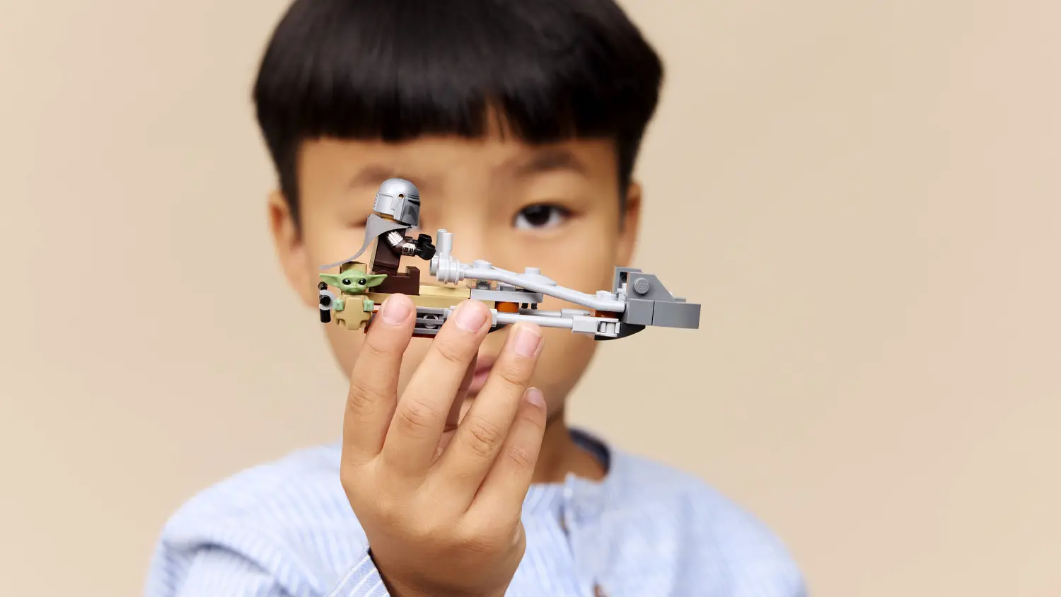 Dieťa drž&iacute; stavebnicu LEGO&reg; Star Wars&trade; 75436 Mandalorian a Grogu a sp&iacute;drov&aacute; motorka