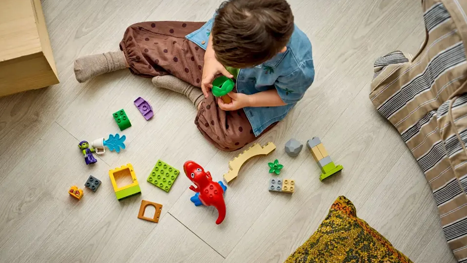 Mal&yacute; chlapec sestavuje stavebnici LEGO&reg; DUPLO&reg; Marvel 10463 Dinosaurus Spidey-Rex vs. Zelen&yacute; goblin.