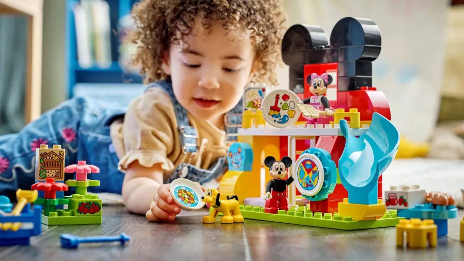 Holčička si hraje se stavebnic&iacute; LEGO&reg; DUPLO&reg; | Disney (10465) a krm&iacute; psa Pluta.