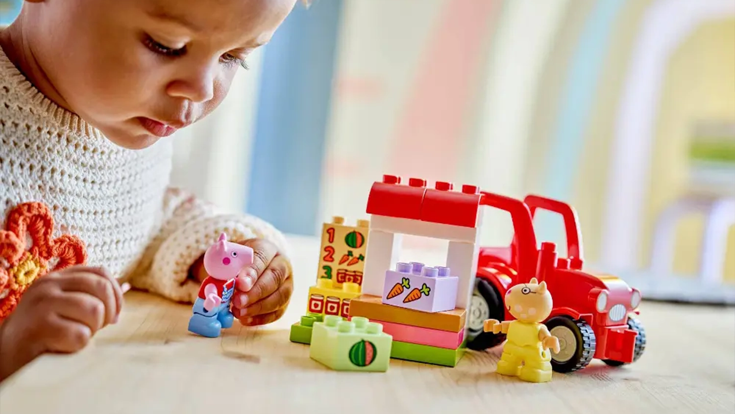 Holčička si hraje se stavebnicí LEGO® DUPLO® Prasátko Peppa 10468 Traktor a tržnice.
