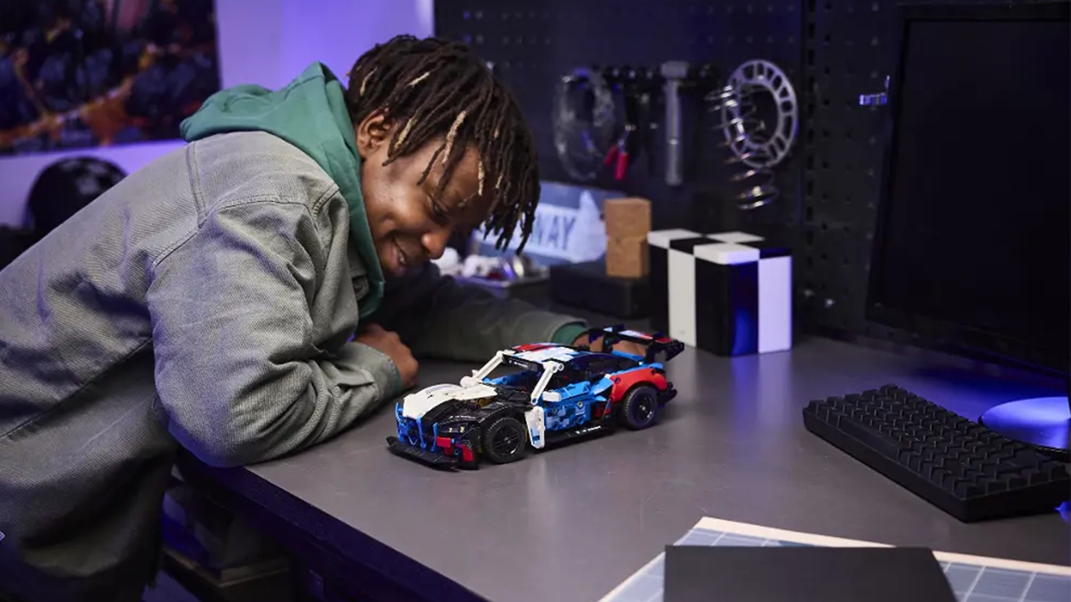 Usm&iacute;vaj&iacute;c&iacute; se chlapec si prohl&iacute;ž&iacute; z&aacute;vodn&iacute; auto BMW M4 GT3 EVO ze stavebnice LEGO&reg; Technic (42226).