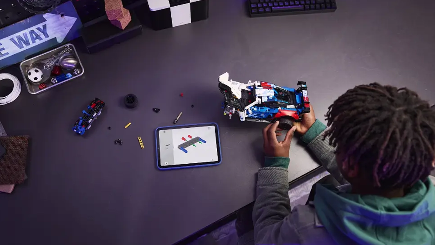 Chlapec sestavuje z&aacute;vodn&iacute; auto BMW M4 GT3 EVO ze stavebnice LEGO&reg; Technic (42226) s pomoc&iacute; n&aacute;vodu v aplikaci LEGO&reg; Builder v tabletu.
