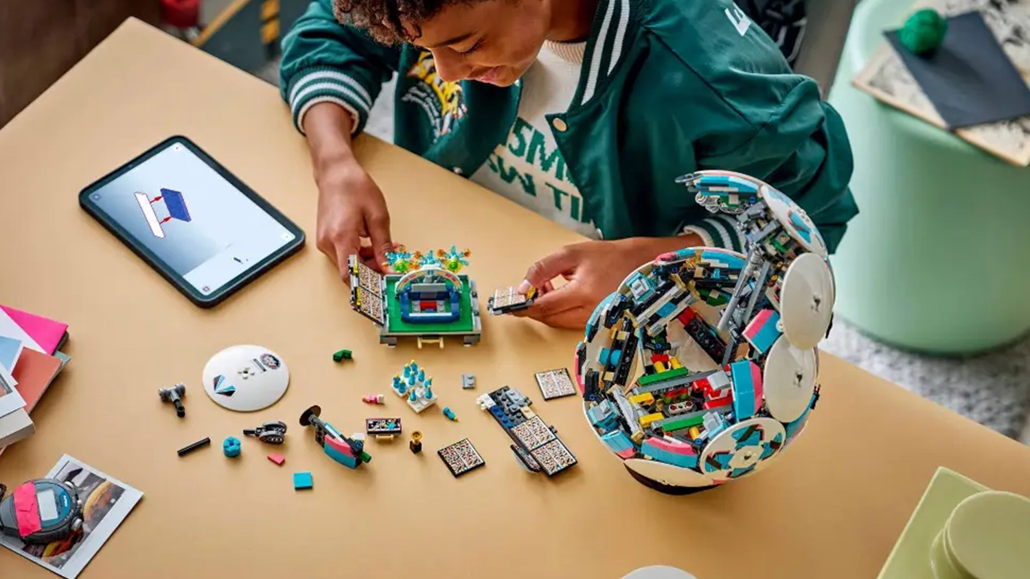 Mladý kluk sestavuje stavebnici LEGO® Editions 43019 Fotbalový míč s pomocí návodu v aplikaci LEGO® Builder na tabletu.
