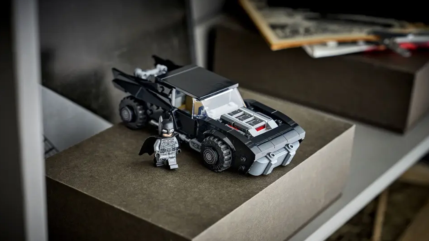 Model Batmobilu ze stavebnice LEGO&reg; DC Batman&trade; (76332) vystaven&yacute; vedle dal&scaron;&iacute;ch replik vozidel, kter&eacute; se prod&aacute;vaj&iacute; zvl&aacute;&scaron;ť.