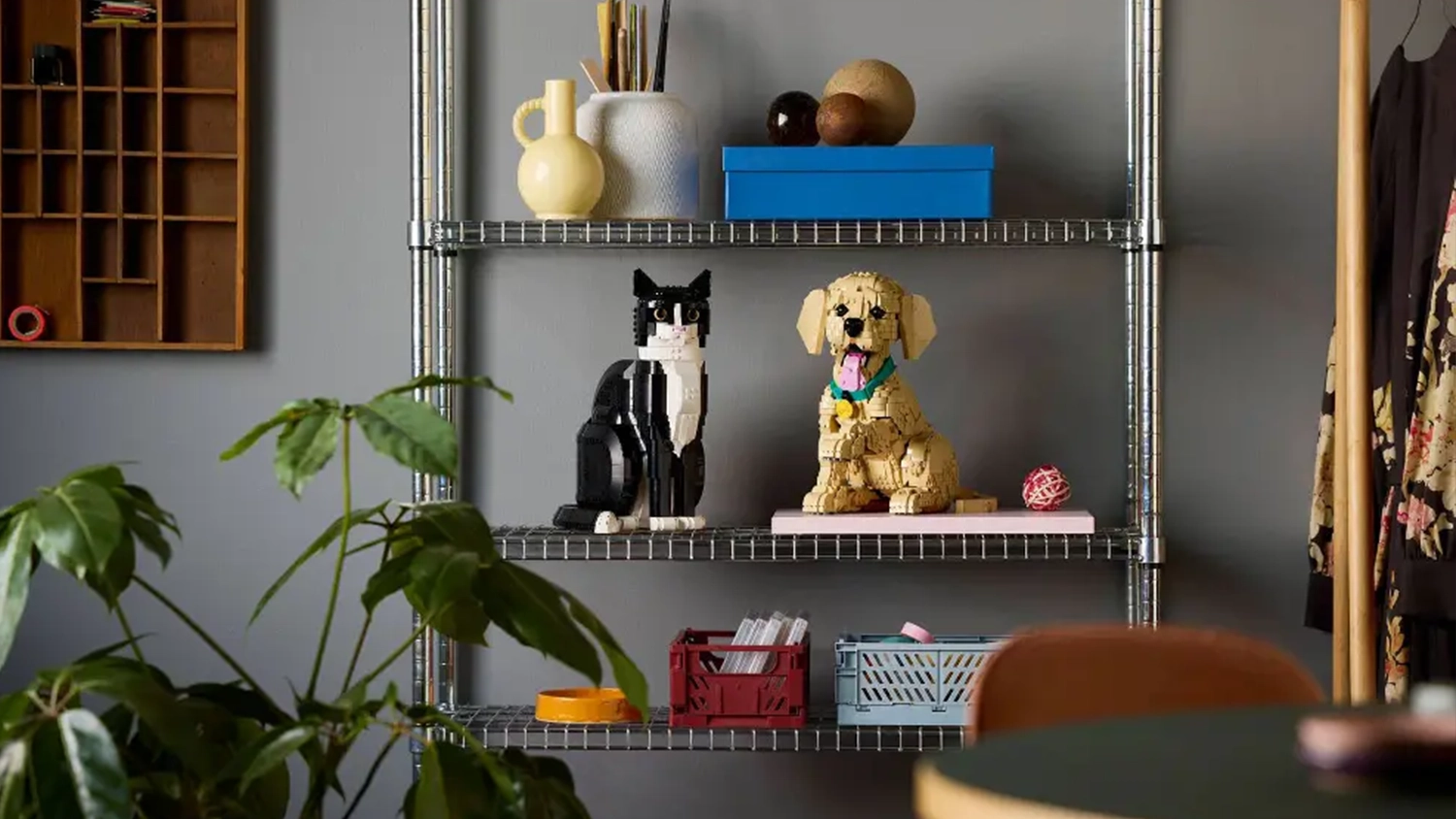 Šteniatko zlatého retrievera zo stavebnice LEGO®vystavené na polici vedľa modelu mačky z rovnakej série LEGO® Icons