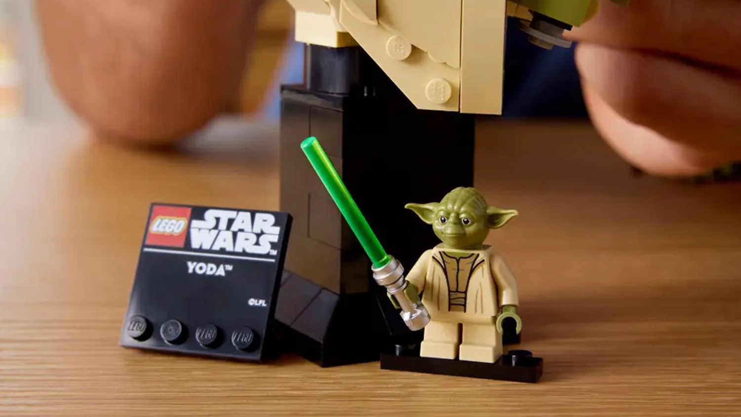 Minifigurka Yody na podstavci ze stavebnice LEGO&reg; Star Wars&trade; (75438) vedle informačn&iacute; cedulky