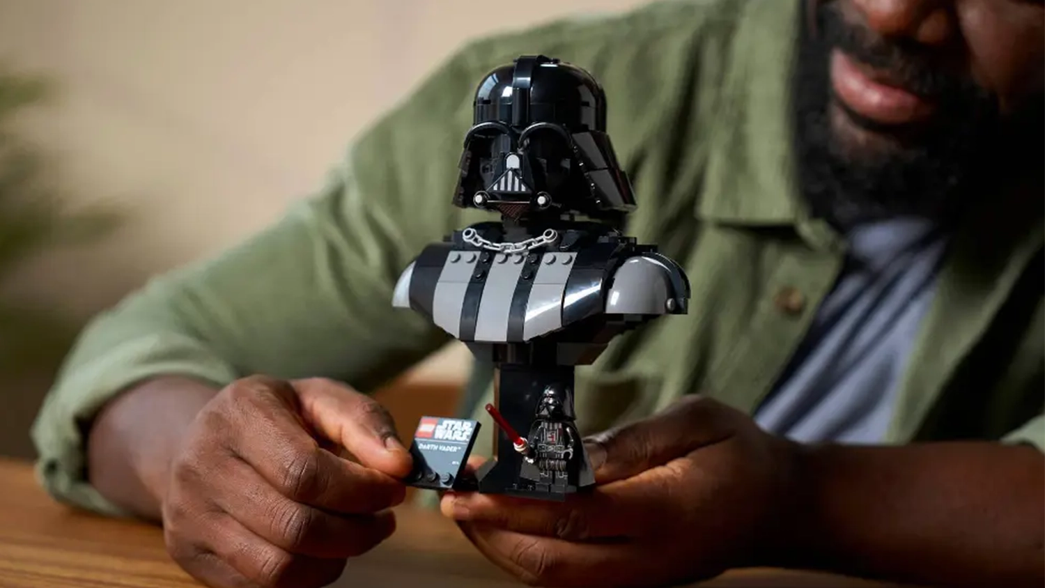 Muž obdivuje bustu Darth Vadera ze stavebnice LEGO® Star Wars™ (75439), kterou drží v ruce.