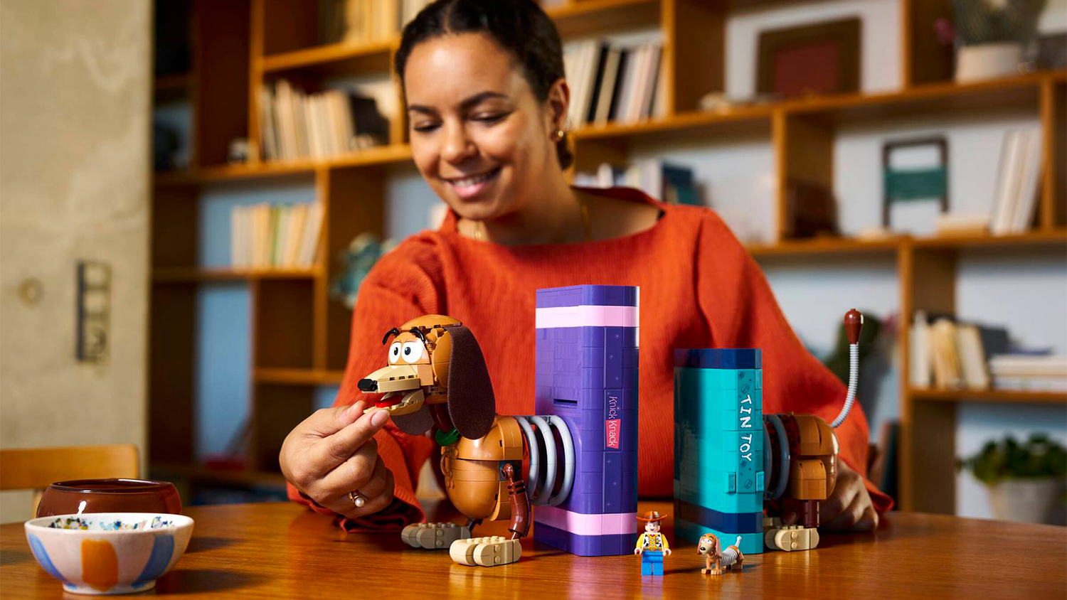 Žena se stavebnicí LEGO® Disney™ 43301 Knižní zarážky: Slinky z filmu Toy Story