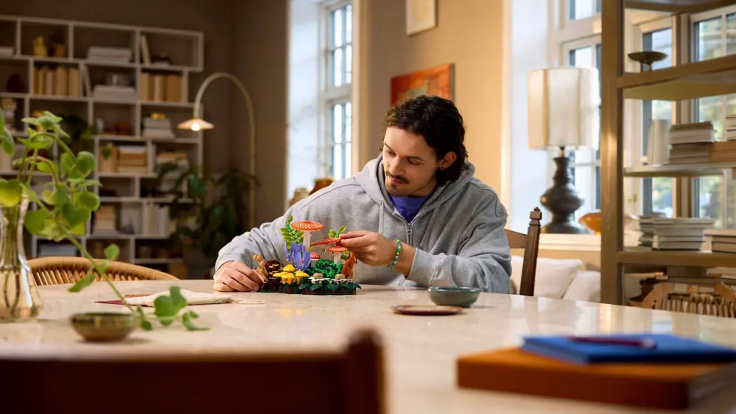 Muž staví stavebnici LEGO® Botanicals 11505 Lesní houby