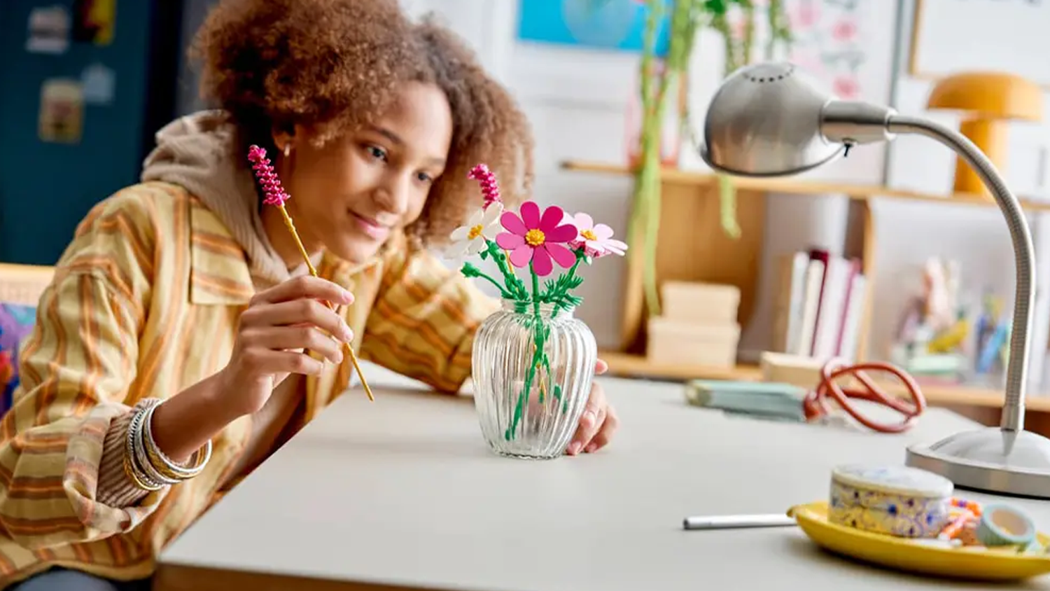 Holčička sestavuje v dětském pokoji stavebnici LEGO® Botanicals 11514 Krásenky