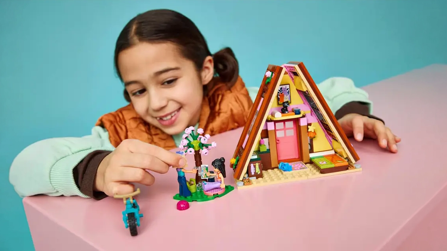 Holčička stav&iacute; stavebnici LEGO&reg; Friends 42682 Glampingov&aacute; chata v př&iacute;rodě