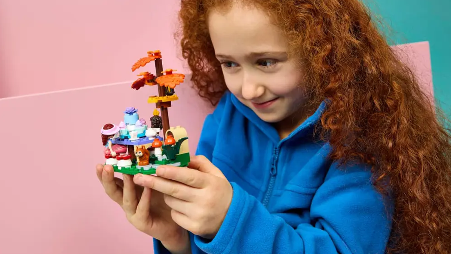 Dievčatko drží zostavený model stavebnice LEGO® Friends 42690 Lesný čajový večierok