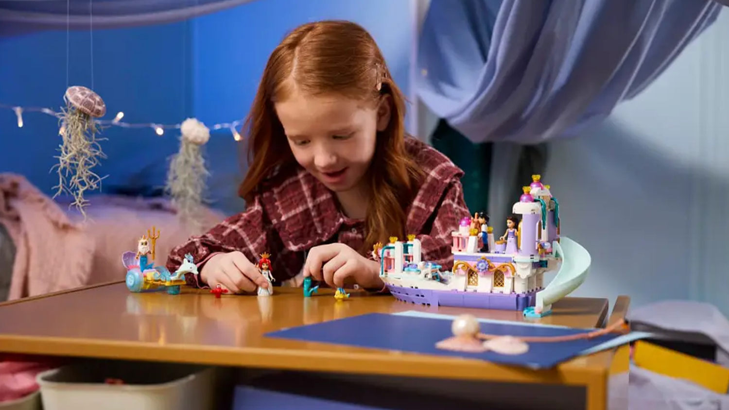 Dívka si hraje se stavebnicí LEGO® Disney Princess® 43299 Arielina loď a královská svatba