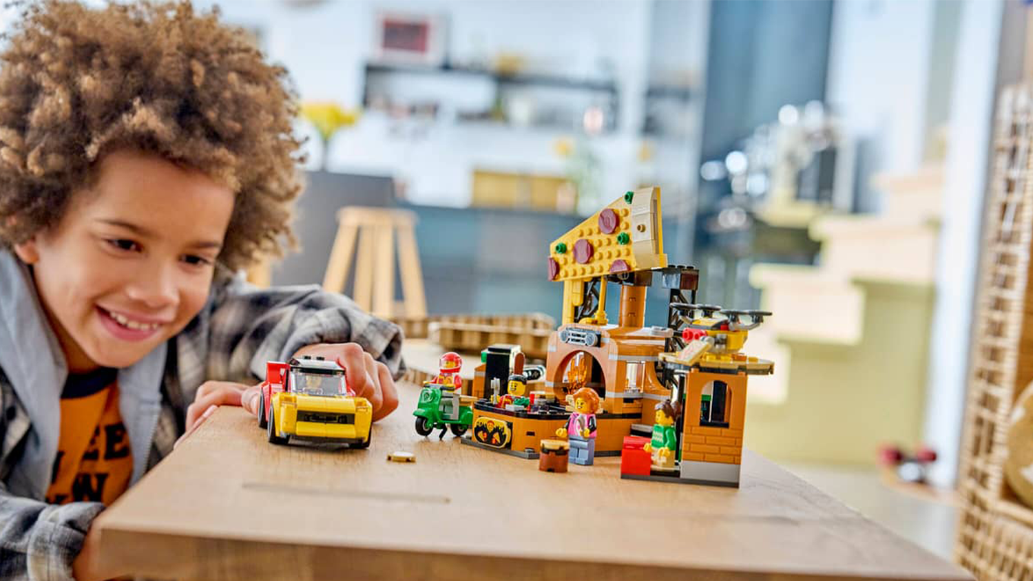 Chlapec si hraje se stavebnicí LEGO® City 60496 Rozvoz pizzy a vozidla