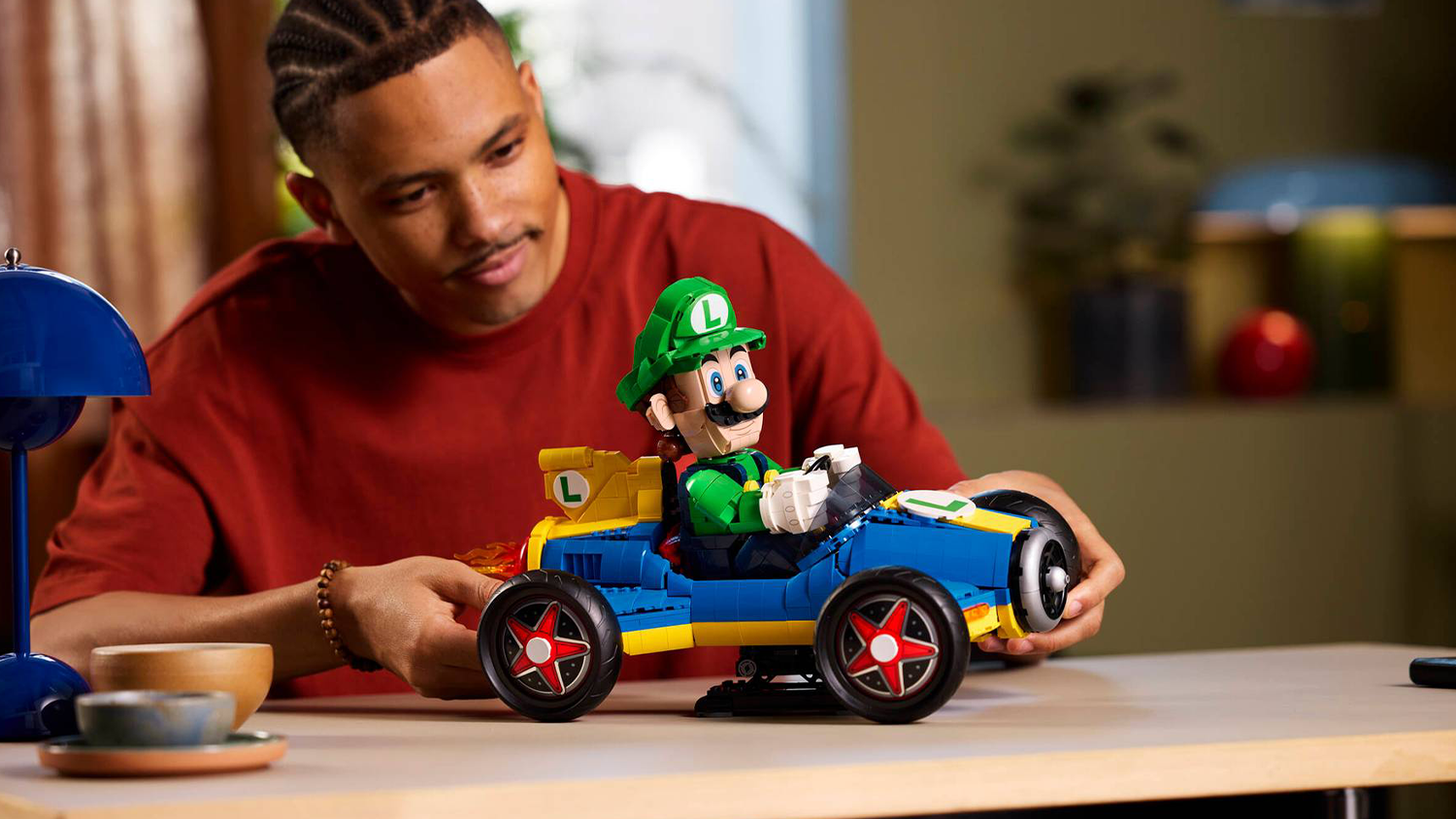 Muž si prohlíží model ze stavebnice LEGO® Super Mario™ 72050 Mario Kart™ – Luigi a Mach 8