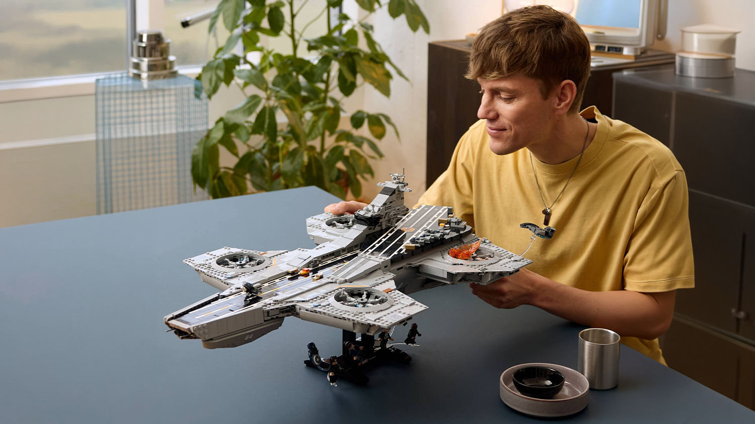 Muž si prohlíží model ze stavebnice LEGO® Marvel 76354 Helicarrier S.H.I.E.L.D.