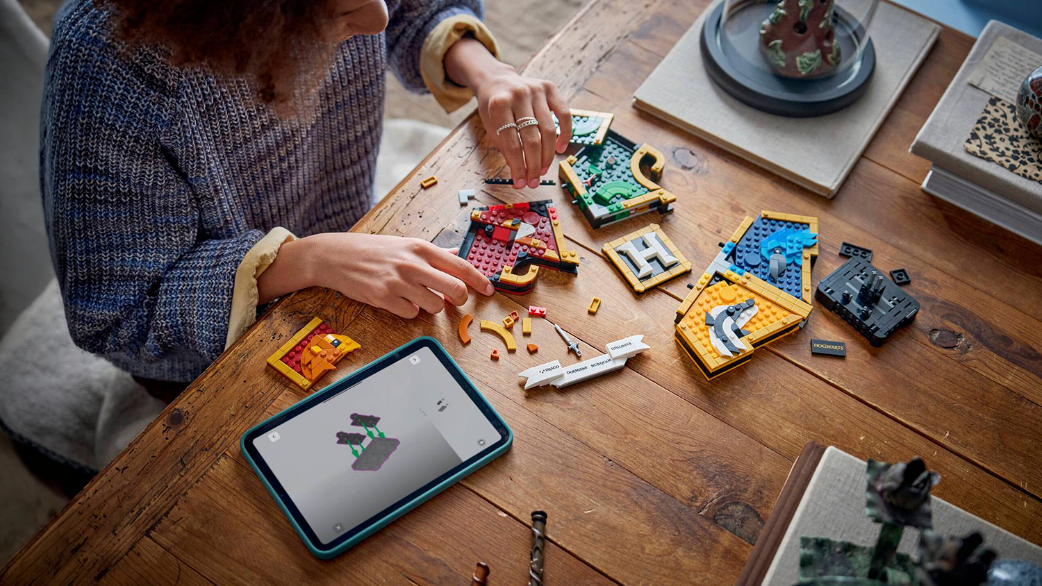 Dievča skládá stavebnicu LEGO® Harry Potter™ 76462 Erb rokfortských fakúlt