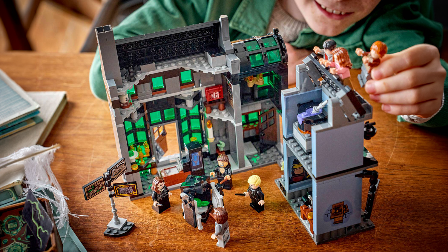 Chlapec sa hrá so stavebnicou LEGO® Harry Potter™ 76471 Kúzelnícke obchody v Zašitej uličke