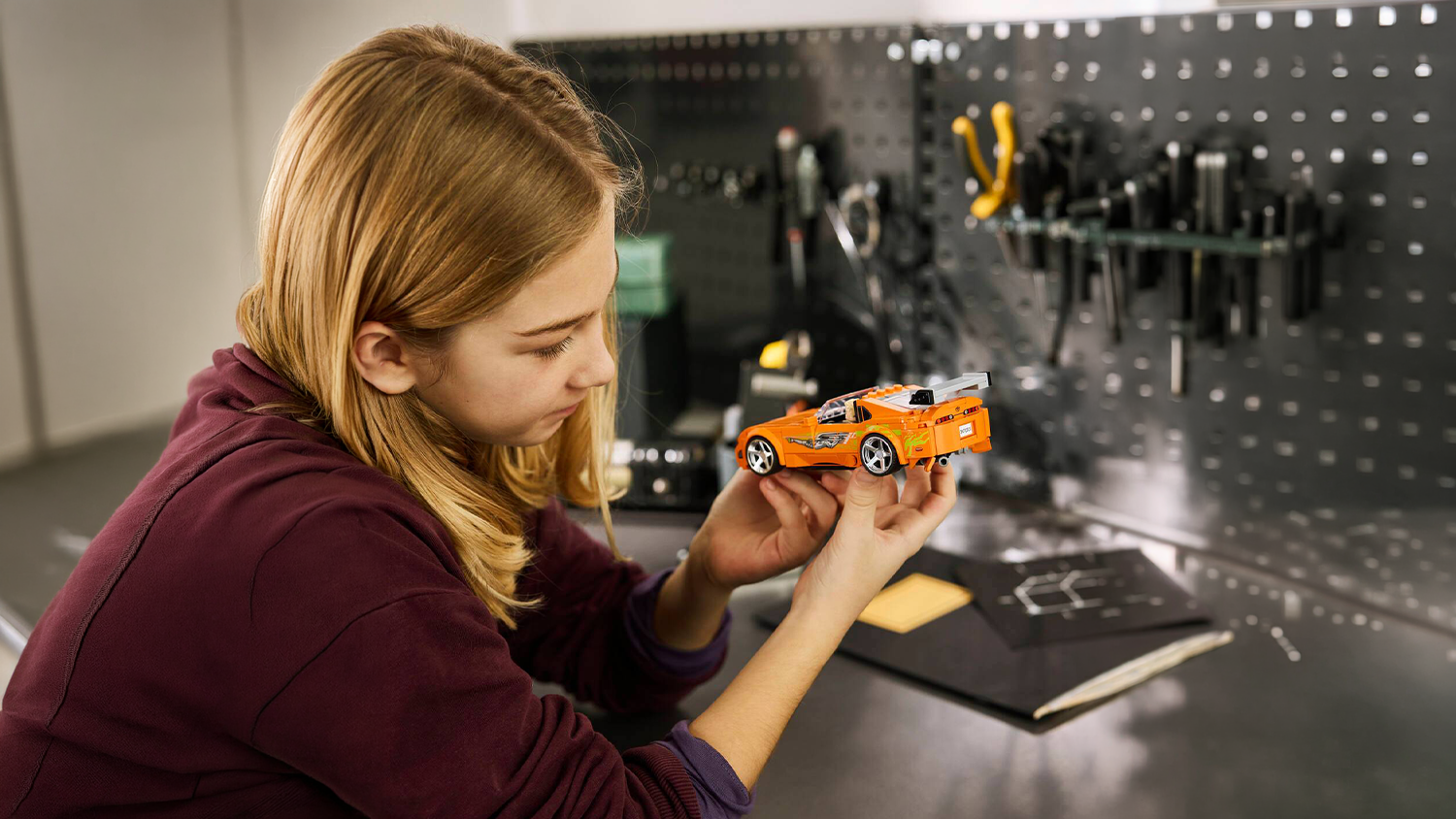D&iacute;vka drž&iacute; model ze stavebnice LEGO&reg; Speed Champions 77260 Rychle a zběsile Toyota Supra MK4