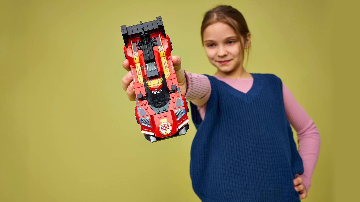 Dievča drží v ruke vozidlo zo stavebnice LEGO® Speed Champions 77261 Ferrari 499P