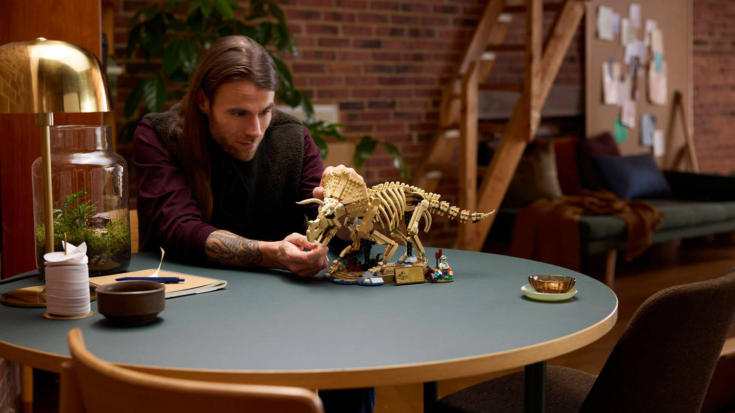 Muž si prohlíží model ze stavebnice LEGO® Jurassic World™ 77985 Dinosauří fosilie: Triceratops