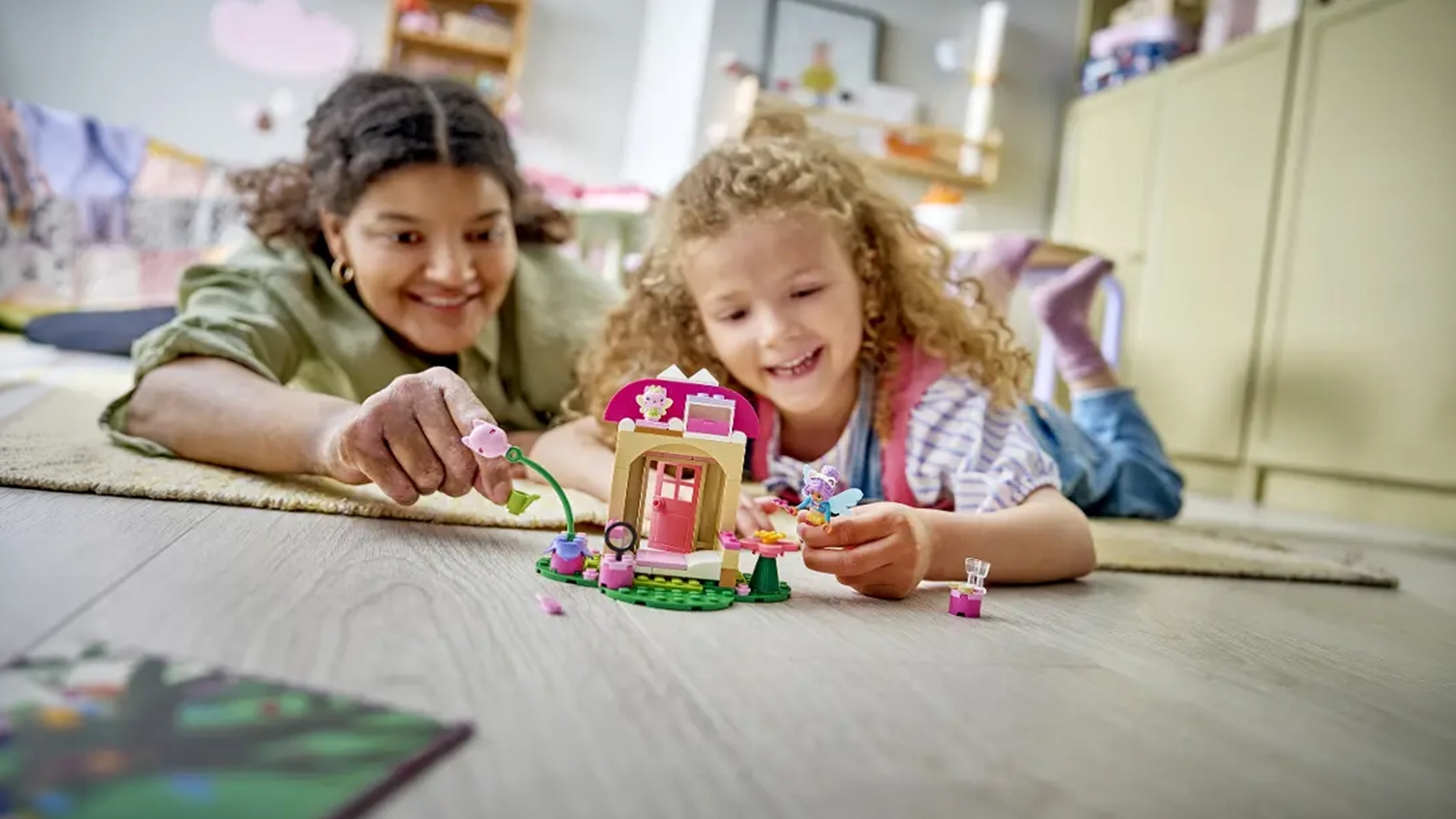 Mama s dcérou skladajú stavebnicu LEGO® Gábinin čarovný domček 11212 Záhradný domček Víly mačičky