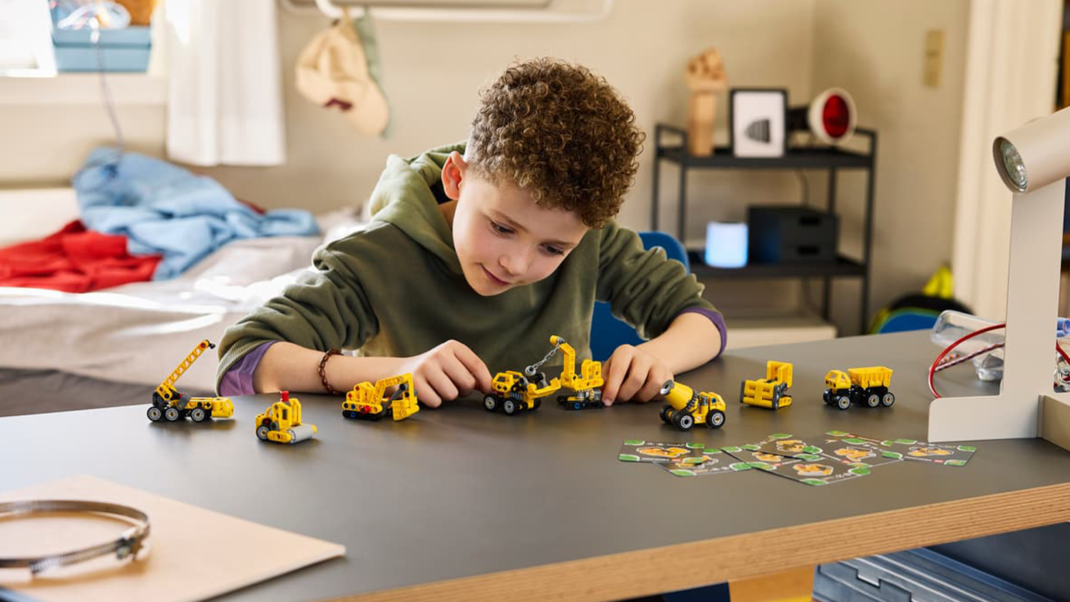 Chlapec sa hr&aacute; so zbierkou modelov zo stavebnice LEGO&reg; 42233 Technic Mocn&eacute; stroje