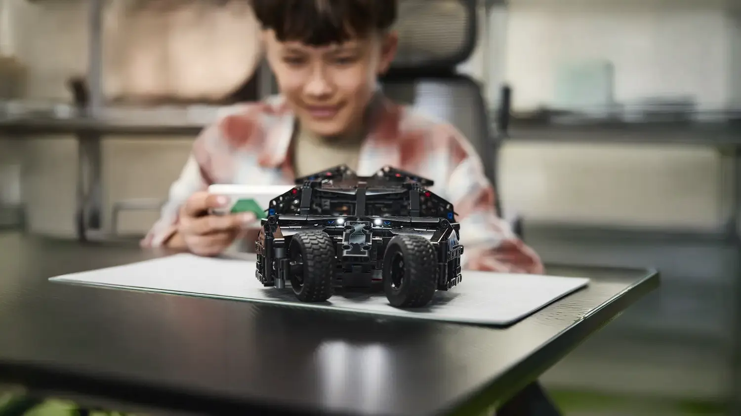 Chlapec ovládající vozidlo Batmobile Tumbler na dálku