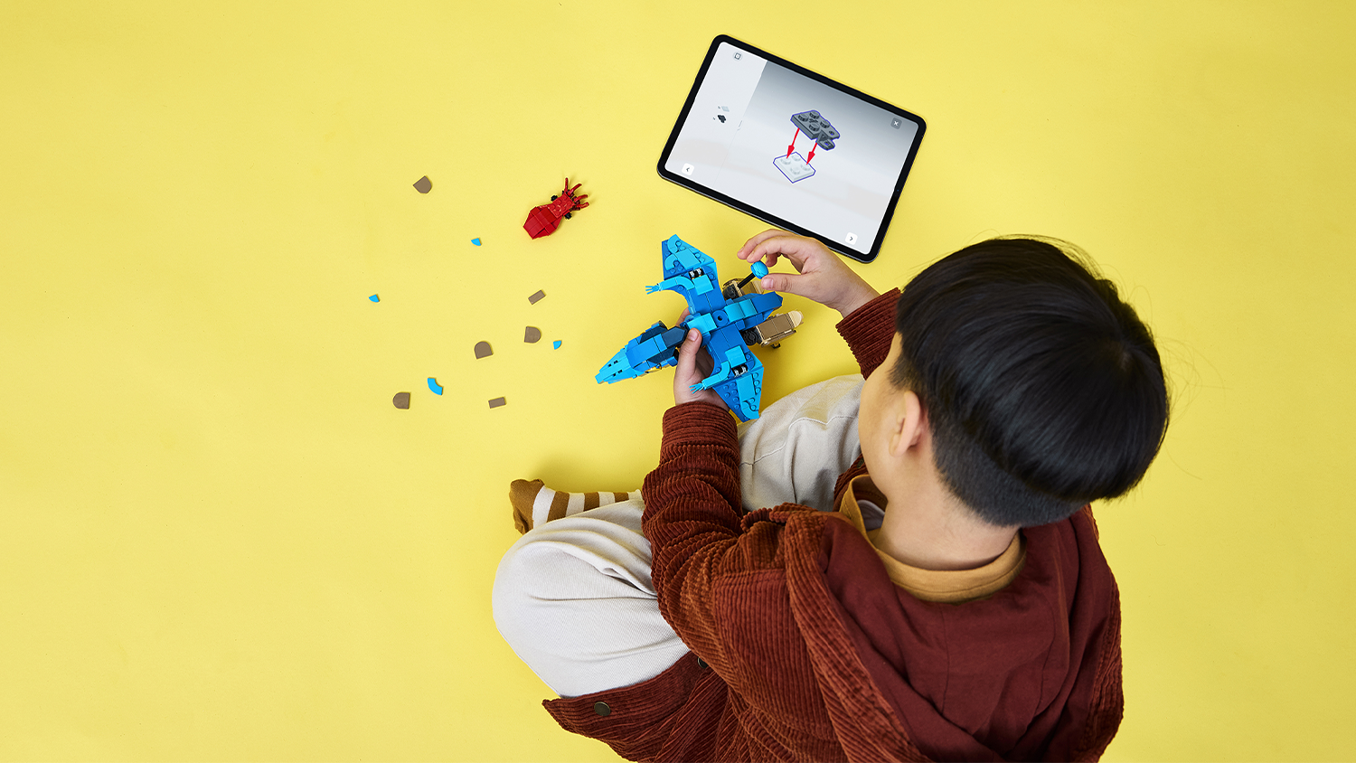 Chlapec stavia podľa návodu v aplikácii LEGO® Builder