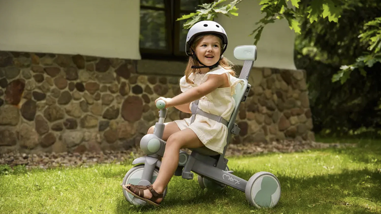 Holčička m&aacute; na sobě cyklistickou helmu MoMi