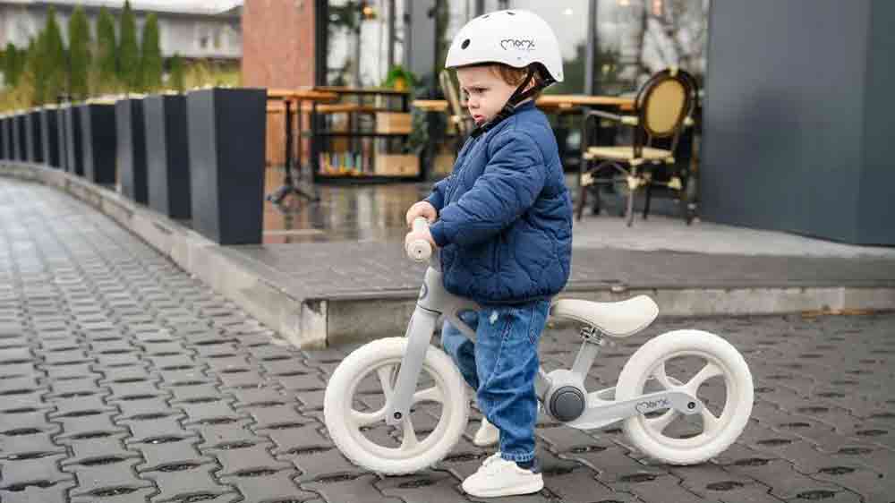 Chlapeček na šedém skládacím odrážedle MoMi NORU_02