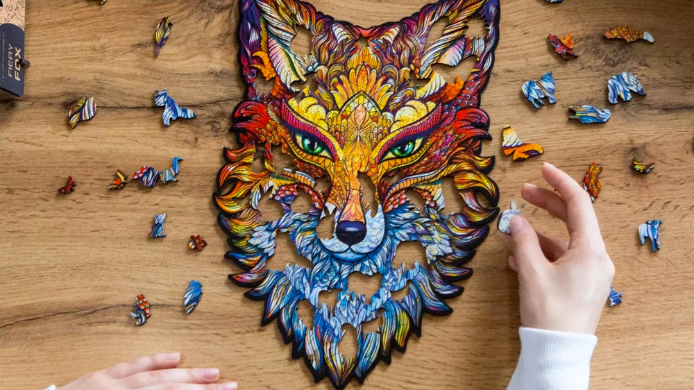 Ruce na dřevěném stole skládající dřevěné puzzle Unidragon Fiery Fox_02