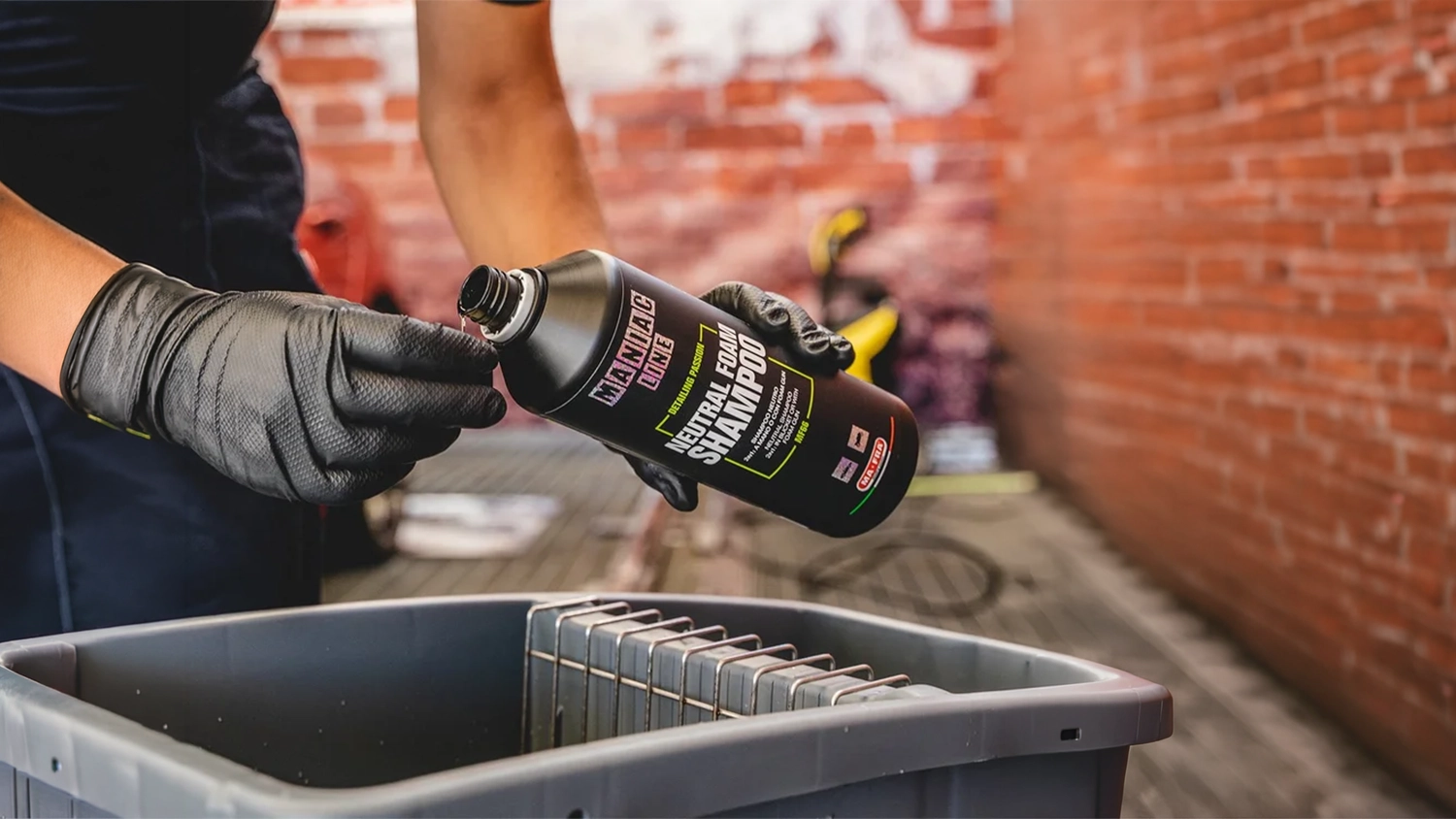 Ruky v gumov&yacute;ch rukaviciach nalievaj&uacute; neutr&aacute;lny &scaron;amp&oacute;n MANIAC 1 000 ml (MF-66) do vedra